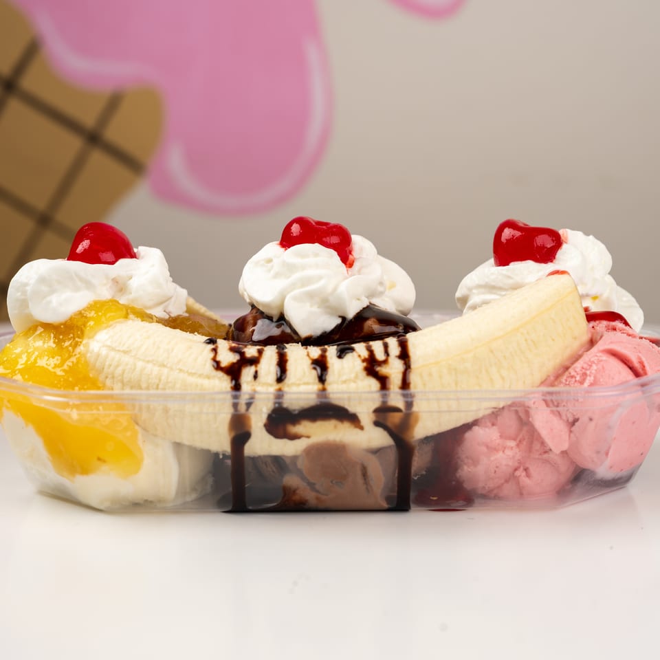 Banana split with vanilla, chocolate, and strawberry ice cream, whipped cream, cherries, fruit topping, and chocolate sauce.